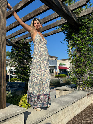 Tall woman in Indigo paisley halter maxi dress with embedded crystals, flowing 62-inch handkerchief hem.