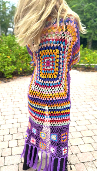 Back close-up of the crochet duster: rainbow granny square over purple lattice with flower squares