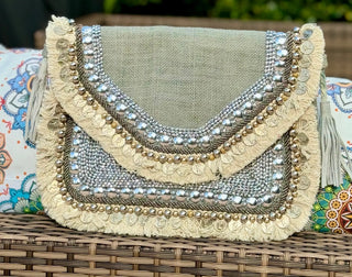 Grey Clutch &amp; Cross Body Purse with embedded silver coins and inrticate beading.  Elevate your wardrobe with our Clutch/Cross Body Purse. Made from luxurious organic burlap with a grey hue and adorned with elegant beige cotton fringe, embroidered silver coins and beads. Includes an inner pocket and chain for versatile use. Perfect for both day and evening, this exclusive bag exudes sophistication and style.  SIZE: 13"X10"