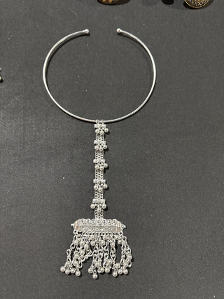 Silver plated necklace with a detailed pendant on a gray background