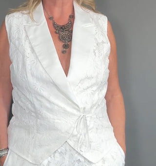 Close-up of the Paloma vest top showcasing its longline cut, structured tuxedo-style flare, and intricate laser-cut floral design — tailored to flatter tall frames with elevated detail.

